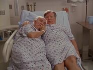 Two old male patients cuddle in one of the beds