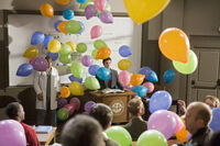 Balloons fall down in the lecture hall.