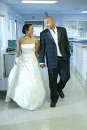 Turk and Carla walk the hallways of Sacred Heart in their wedding attire