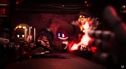 Doll pointing a bullet at Uzi next to V