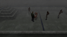 James surrounded by three Lying Figures in an empty pool.