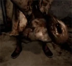 Пирамидоголовый держит Лежачую фигуру