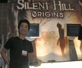 Akira frente a un cartel promocional de Silent Hill: Origins.