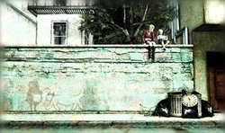 Laura y María sentadas en el muro.