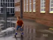 SkatingOutSchoolLA.png (220 KB) Bart flying out of school in the Sky One/live-action opening sequence