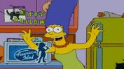 Marge is telling everyone about Halloween, but suddenly "American Idol" appears.