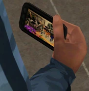 A Sim watching a video on his smartphone in The Sims 3: University Life