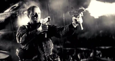 Ronnie fires a pair of Micro Uzis at Dwight McCarthy (Clive Owen).