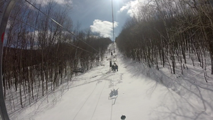 The second half of the lift cuts through the woods.