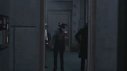 Camerawoman looking at the Detective Cameraman as he walks out the room.