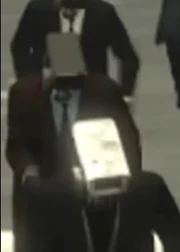 Камерамен в коричневом пальто с чёрной камерой