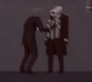 Обычный Спикермен надевает Камикадзе Камерамену пояс Смертника