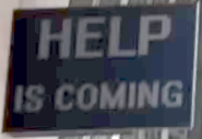 HELP IS COMING (рус. Помощь приближается) (надпись на одном из столбов в городе)