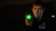 holding a gun with green kryptonite bullets