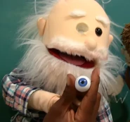 Holding his glass eye