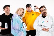 Shayne, Courtney, Damien, Ian in various Smosh clothes and carrying Smosh water bottles