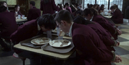 Students forced to eat with their hands tied behind their back.