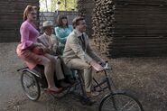 Shirley, Sir and Dr. Orwell being cycled by Charles.