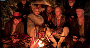 Count Olaf, Esmé and Count Olaf’s Troupe beside a fire.