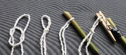 I use a simple 'thumb knot loop' (the proper name for this is a marlinspike hitch) which you can either tighten onto the end of your stick or pull tight to make a loop and then hook into the carabiner or whatever you are using on the end of your stick. I personally favour a simple clothes peg.