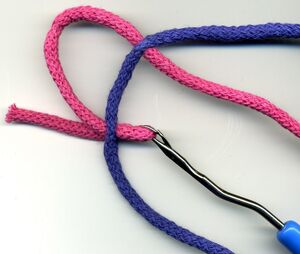 A latch hook tool being used to splice two braided lines