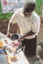 Gaudenziah Wedende pours sun cooked tea for a customer