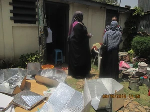 Mama solar demonstrates how solar cookers and fireless cookers (insulated baskets) operates to guests at her home.