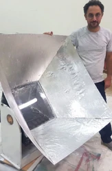 Amir Komarizade standing with his solar box cooker incorporating a Dobsonian, or gimbal style, mounting system. -Photo credit: Amir Komarizade]]