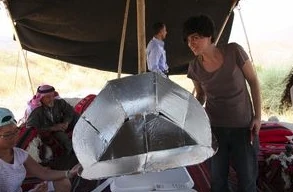 Instructor  helps with the solar cooker assembly.