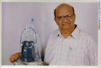 Dr. Jagadeesh with his cost-effective solar water heater: a stainless steel jar painted black covered with a polyethylene sheet