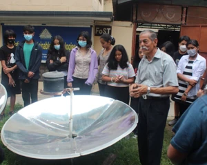 A parabolic solar cooker is demonstrated to the students - Photo credit: FoST