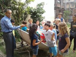 Students feel the heat of the solar cooker - Photo credit: FoST