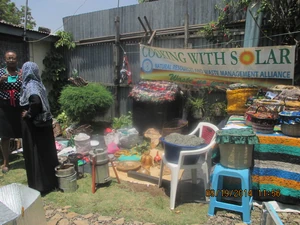 Mama solar of NAREWAMA displays fireless cookers, energy saving stoves, and recycled plastic wastes to guests at her home.