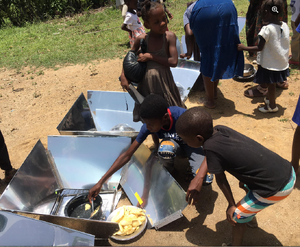 Young solar chefs attend to cooking the breadfruit