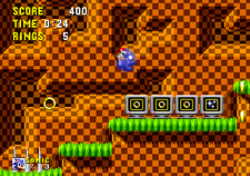 Screenshot of a similar area as the previous image, this time having Sonic above four monitors: the first three depict a ring, while the fourth one has three stars in it.