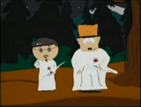 A Visitor watches Jimbo and Ned in KKK uniform in "Chef Goes Nanners".