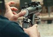 A less-lethal round is loaded into an M79.