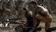 Nasir and Agron kneeling over Castus' dead body.