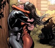 Hawkeye and Spider-Woman romantically embrace each other.