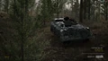 A FV432 on the move through a forest.