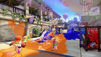 Inklings disparando tinta en un combate territorial en Splatoon