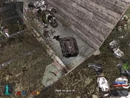 The backpack is on the side of the truck, which is on the ground.