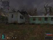 Go around the end of the fence on the other side of the sniper platform.