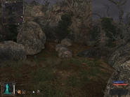 Hidden behind the boulders.