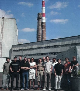 Слева от центра, в белой футболке