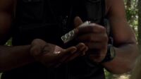 Teal'c inspecting broken Tretonin vial.