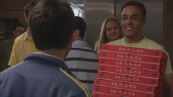  holding a stack of pizzas in boxes