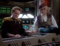An alien in the form of Rumpelstiltskin watches O'Brien.