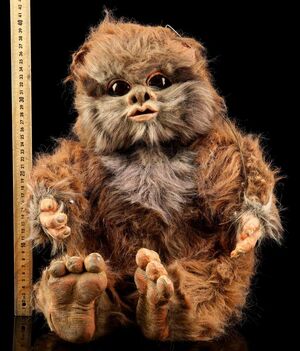 With slightly matted fur and some wear, the Nippet puppet sites beside a ruler.