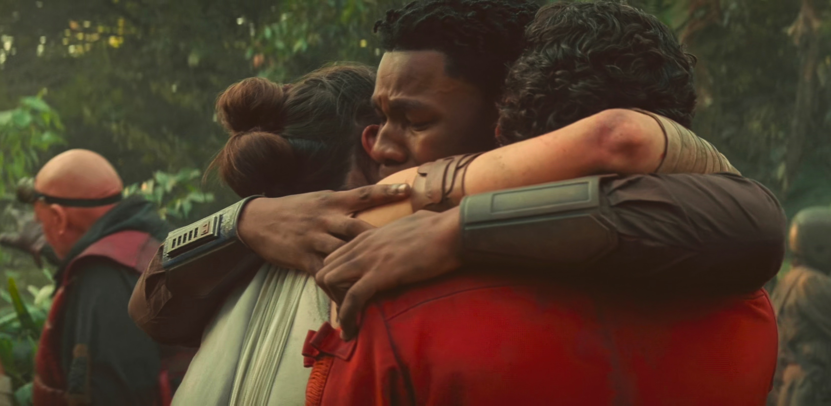 Finn, Rey, and Poe share a hug on Ajan Kloss after their hard fought victory.